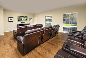 A living room with a row of brown leather couches.